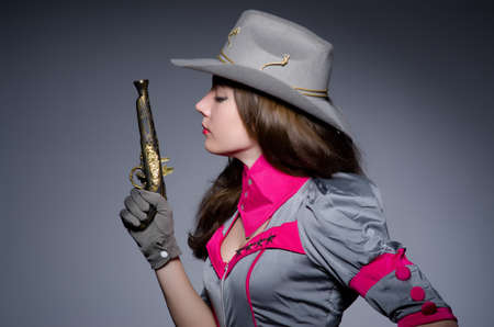 Woman cowgirl with gun in studio