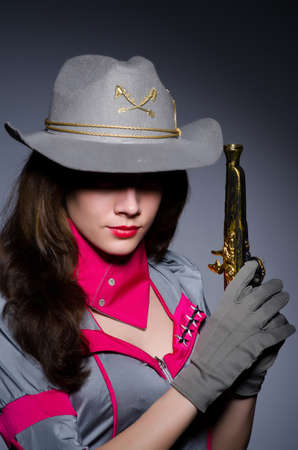 Woman cowgirl with gun in studio
