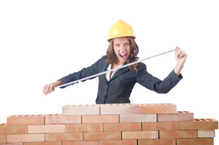 Woman builder measuring isolated on the whiteの写真素材