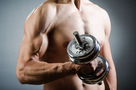 Muscular ripped bodybuilder with dumbbellsの写真素材