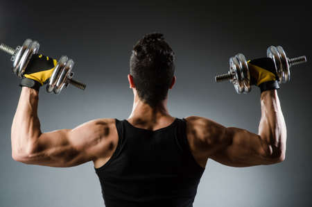 Muscular ripped bodybuilder with dumbbellsの写真素材