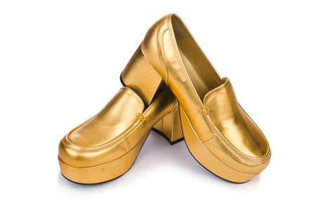 Golden woman shoes isolated on the whiteの写真素材