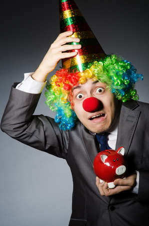 Clown with piggybank in funny conceptの写真素材