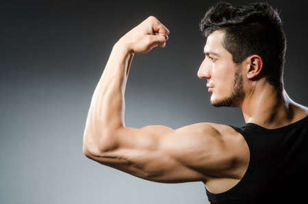 Muscular man posing in dark studioの写真素材