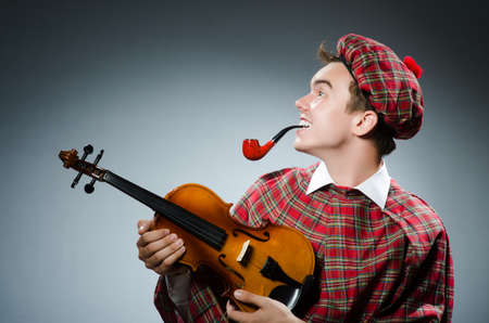 Funny scotsman with violin fiddleの写真素材