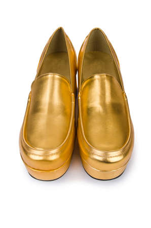Golden woman shoes isolated on the whiteの写真素材