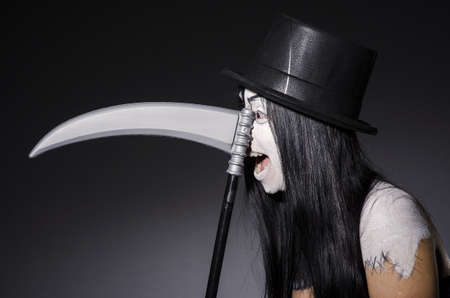 Woman in halloween concept with scytheの写真素材