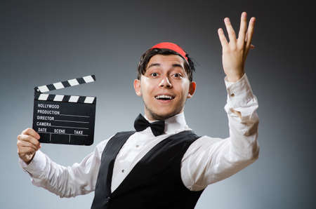 Man with movie board wearing fez hatの写真素材