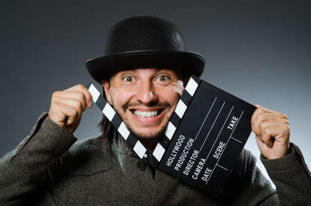 Man with movie clapperboard and hat