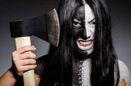 Scary woman with metal axe in halloween conceptの写真素材