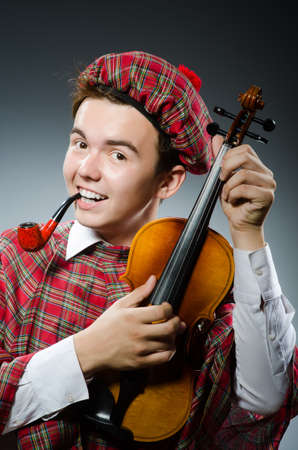 Funny scotsman with violin fiddleの写真素材