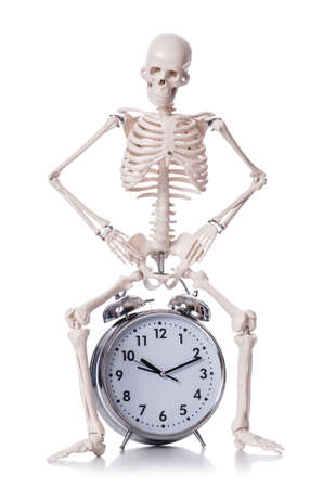 Skeleton with alarm clock on the whiteの写真素材