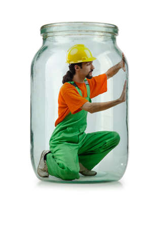 Man in coveralls imprisoned in glass jarの写真素材