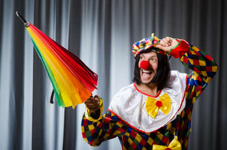 Funny clown with colourful umbrella