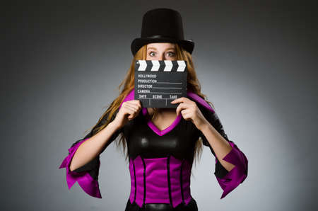 Woman with movie clapboard against grey backgroundの写真素材