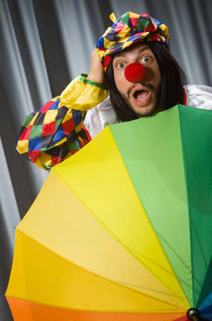 Funny clown with colourful umbrella の写真素材