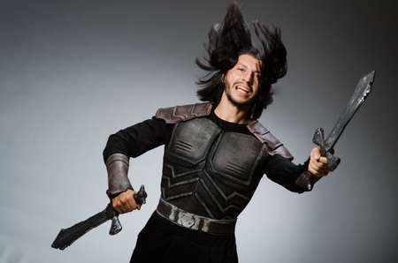 Angry knight with sword against dark backgroundの写真素材