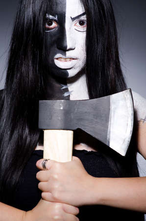 Scary woman with metal axe in halloween concept