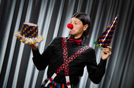 Funny clown in humorous concept against curtain