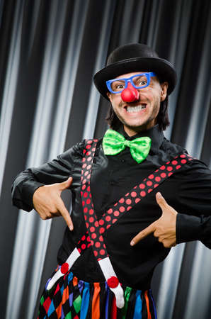 Funny clown in humorous concept against curtainの写真素材