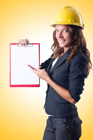 Woman with hard hat and binderの写真素材