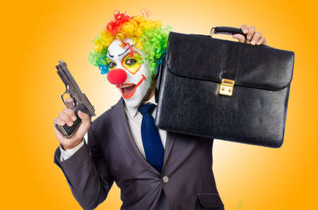 Businessman clown with gun isolated on whiteの写真素材