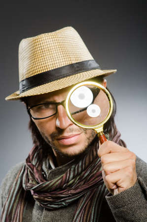 Funny detective with smoking pipe and magnifying glassの写真素材