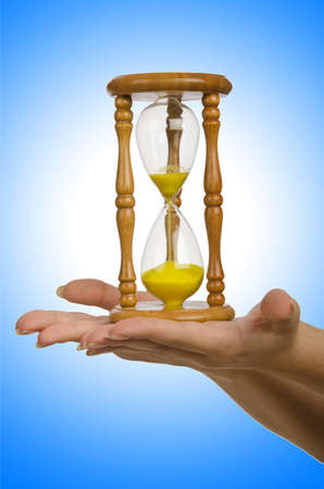 Hand holding hourglass on white