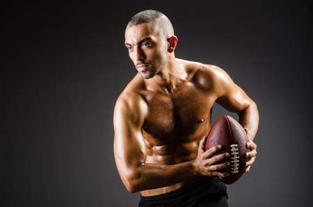 Muscular football player with ballの写真素材
