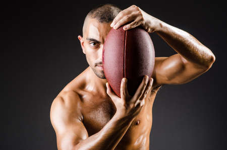 Muscular football player with ballの写真素材