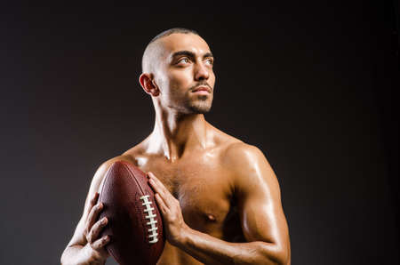 Muscular football player with ballの写真素材