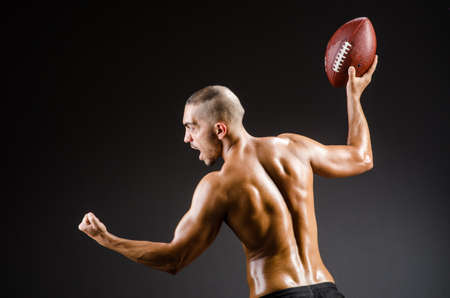 Muscular football player with ballの写真素材