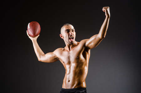 Muscular football player with ballの写真素材