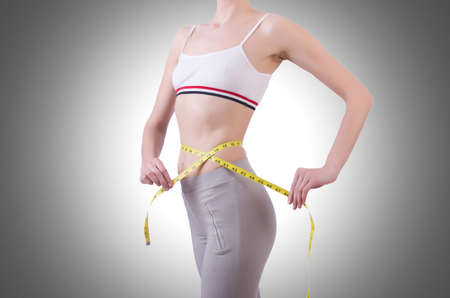 Young girl with centimeter in dieting conceptの写真素材