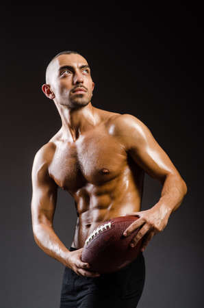Muscular football player with ballの写真素材