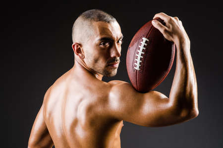 Muscular football player with ballの写真素材