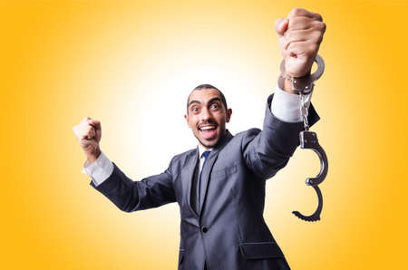 Funny businessman with handcuffs on whiteの写真素材
