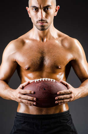 Muscular football player with ballの写真素材