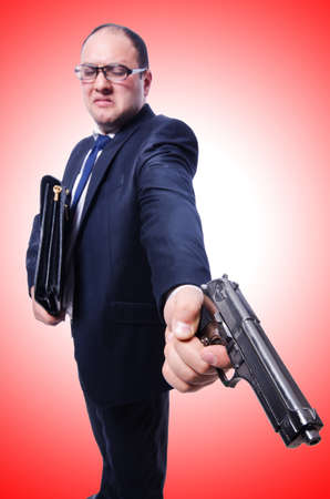 Businessman with gun isolated on whiteの写真素材