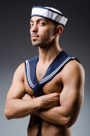 Ripped sailor against dark backgroundの写真素材