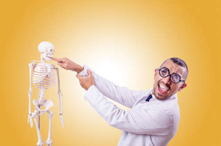 Funny doctor with skeleton isolated on whiteの写真素材