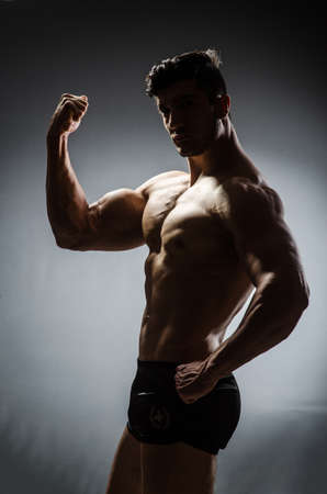 Muscular man posing in dark studioの写真素材