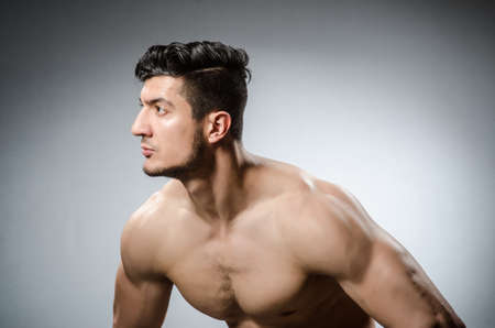 Muscular man posing in dark studioの写真素材