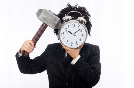 Businessman holding hammer and alarm clock isolated on whiteの写真素材
