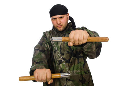 Young man in soldier uniform holding nunchaks isolated on whiteの写真素材