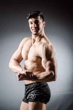 Muscular man posing in dark studioの写真素材