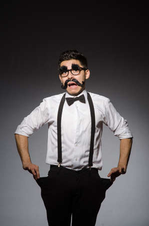 Young man with false moustache isolated on grayの写真素材