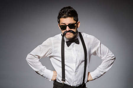 Young man with false moustache isolated on grayの写真素材