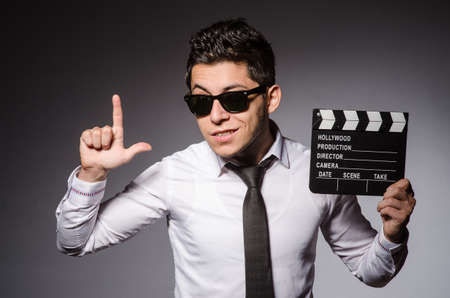 Young man in cool sunglasses holding chalkboard isolated on grayの写真素材