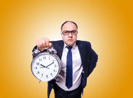 Businessman with clock against the gradientの写真素材